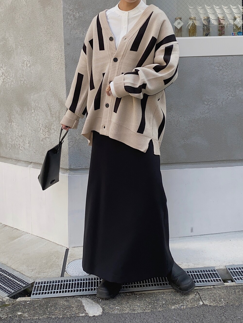 ベージュ系のカーディガン/ボレロ、ブラック系のブーツ、ホワイト系のシャツ/ブラウスを着用したレディースの秋コーディネートの2枚目の写真