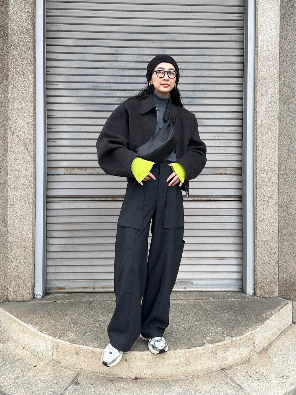 グレー系のブルゾン、ブラック系のショルダーバッグ、グリーン系のカーゴパンツを着用したレディースの冬コーディネートの2枚目の写真