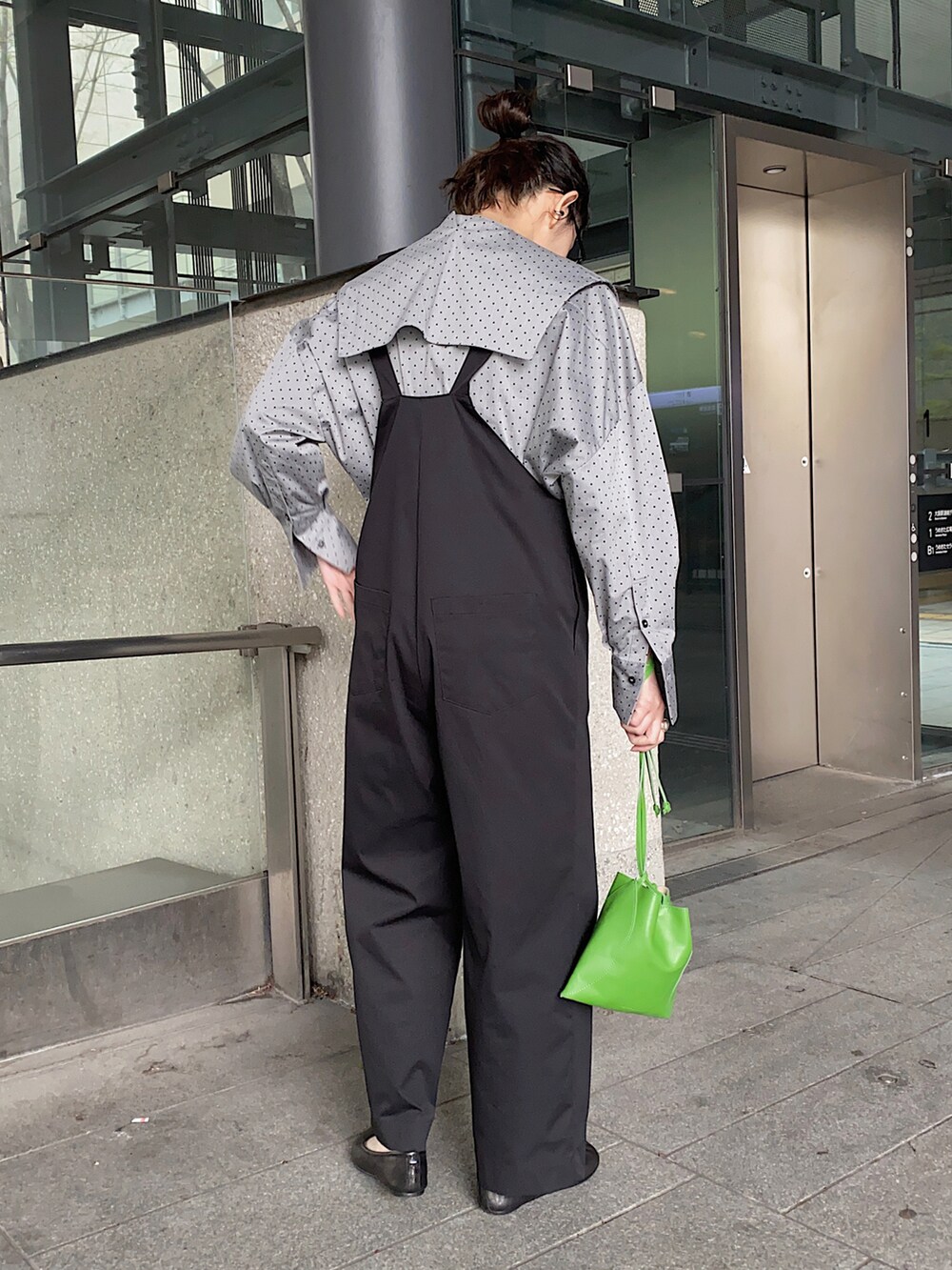 ブラック系のシャツ/ブラウス、ブラック系のサロペット/オーバーオール、グリーン系のハンドバッグを着用したレディースの春コーディネートの3枚目の写真