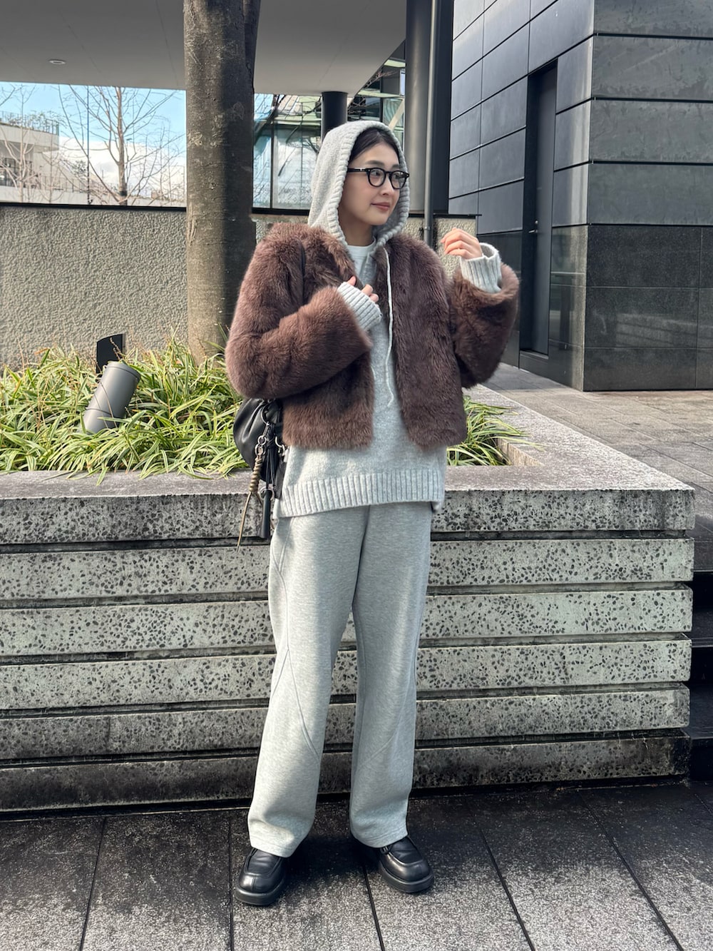 ブラウン系のその他アウター、グレー系のニット/セーター、ブラック系のキーホルダーを着用したレディースの冬コーディネートの4枚目の写真