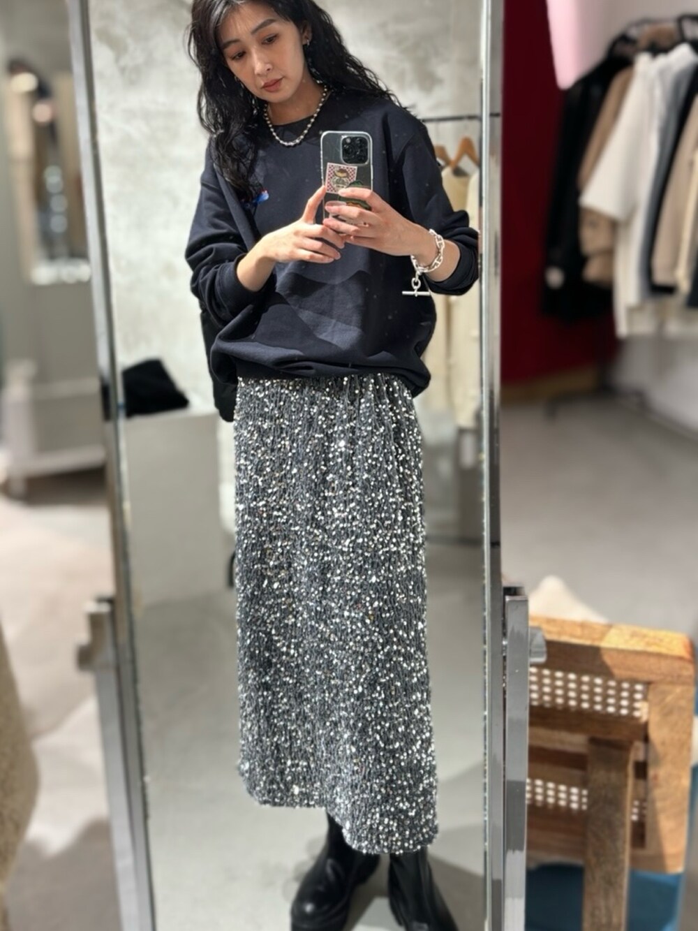 ブルー系のスウェット、シルバー系のスカート、ブラック系のブーツを着用したレディースの秋コーディネートの3枚目の写真