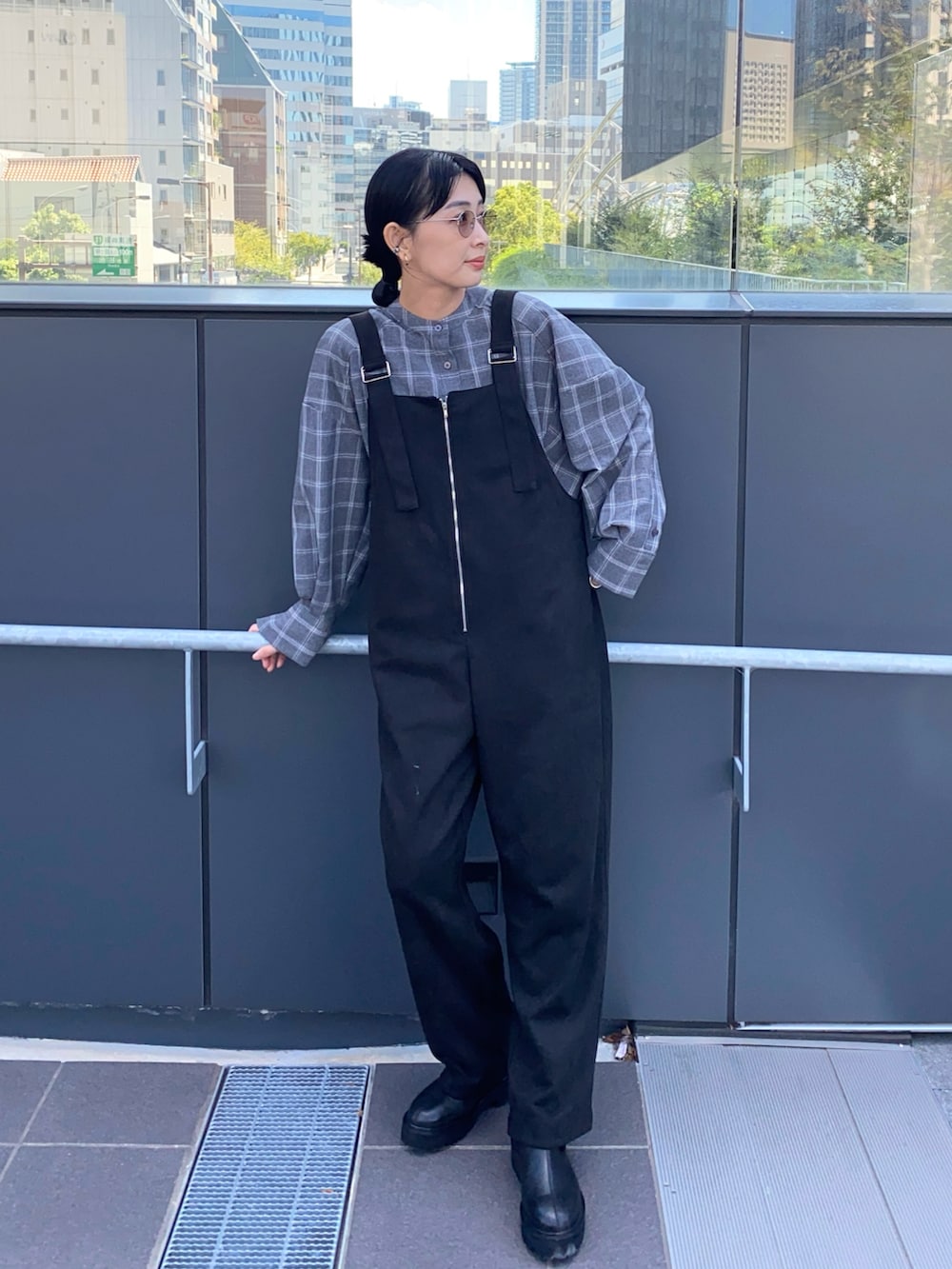 ブラック系のサロペット/オーバーオール、グレー系のシャツ/ブラウス、ブラック系のブーツを着用したレディースの冬コーディネートの3枚目の写真