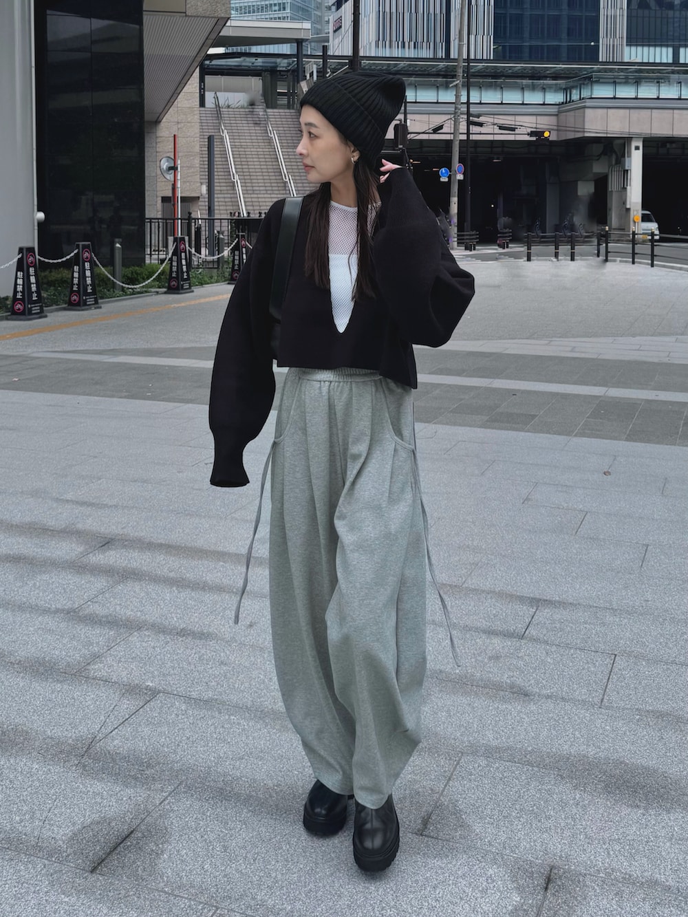 ブラック系のニット/セーター、グレー系のスウェットパンツ、ブラック系のショルダーバッグを着用したレディースの秋コーディネートの2枚目の写真