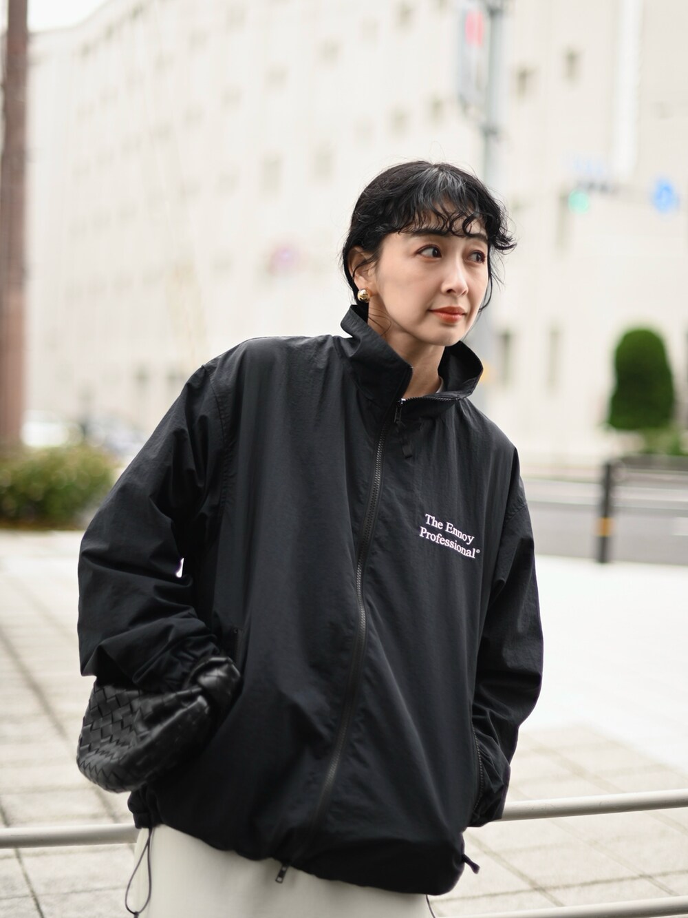 ブラック系のナイロンジャケット、ホワイト系のスカート、ブラック系のスニーカーを着用したレディースの冬コーディネートの4枚目の写真