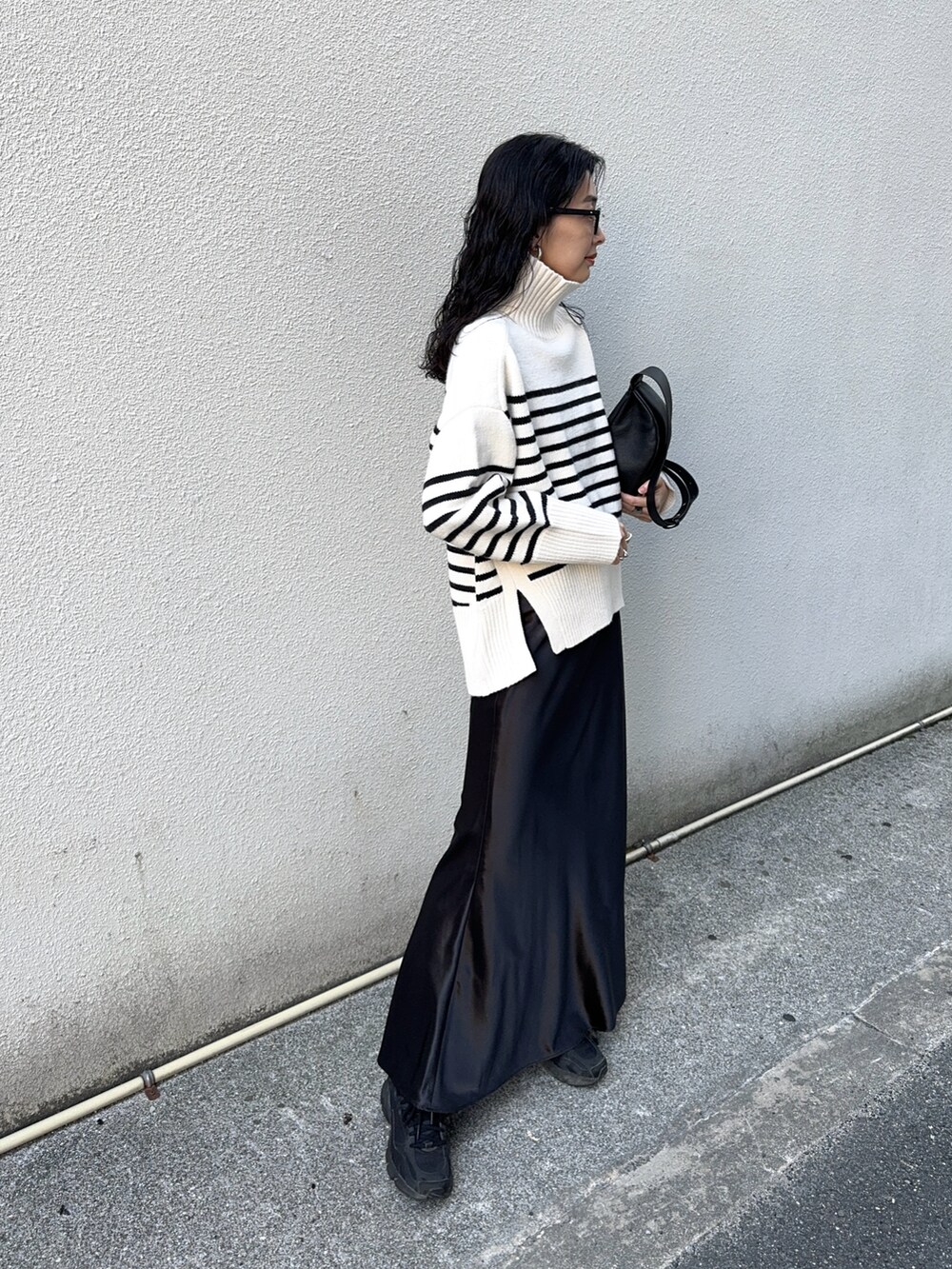 ホワイト系のニット/セーター、ブラック系のスカート、ブラック系のスニーカーを着用したレディースの冬コーディネートの5枚目の写真