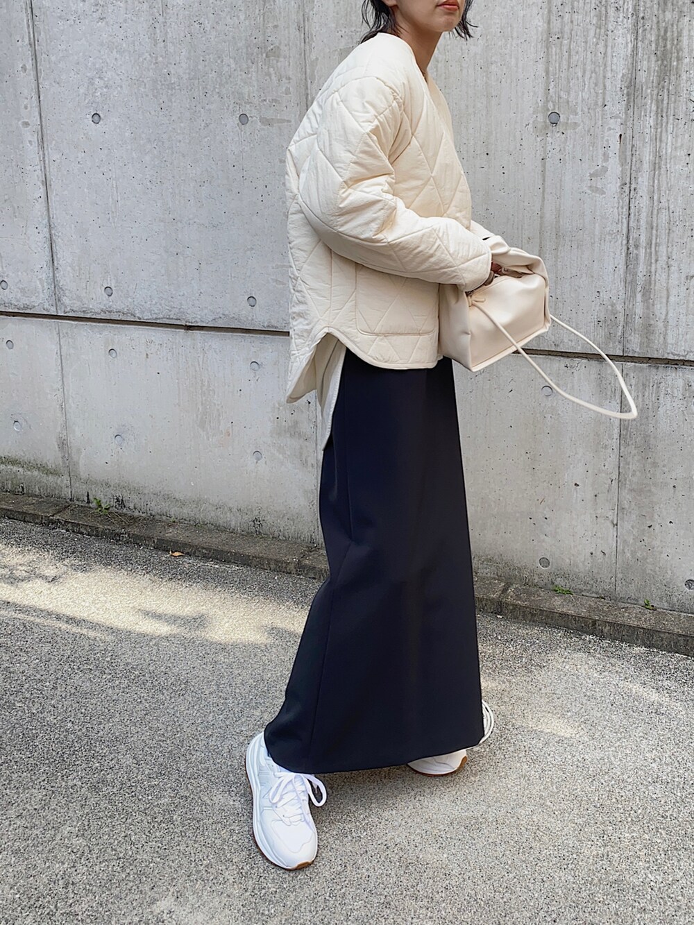 ホワイト系のダウンジャケット/コート、ホワイト系のハンドバッグ、ブラック系のスカートを着用したレディースの冬コーディネートの2枚目の写真