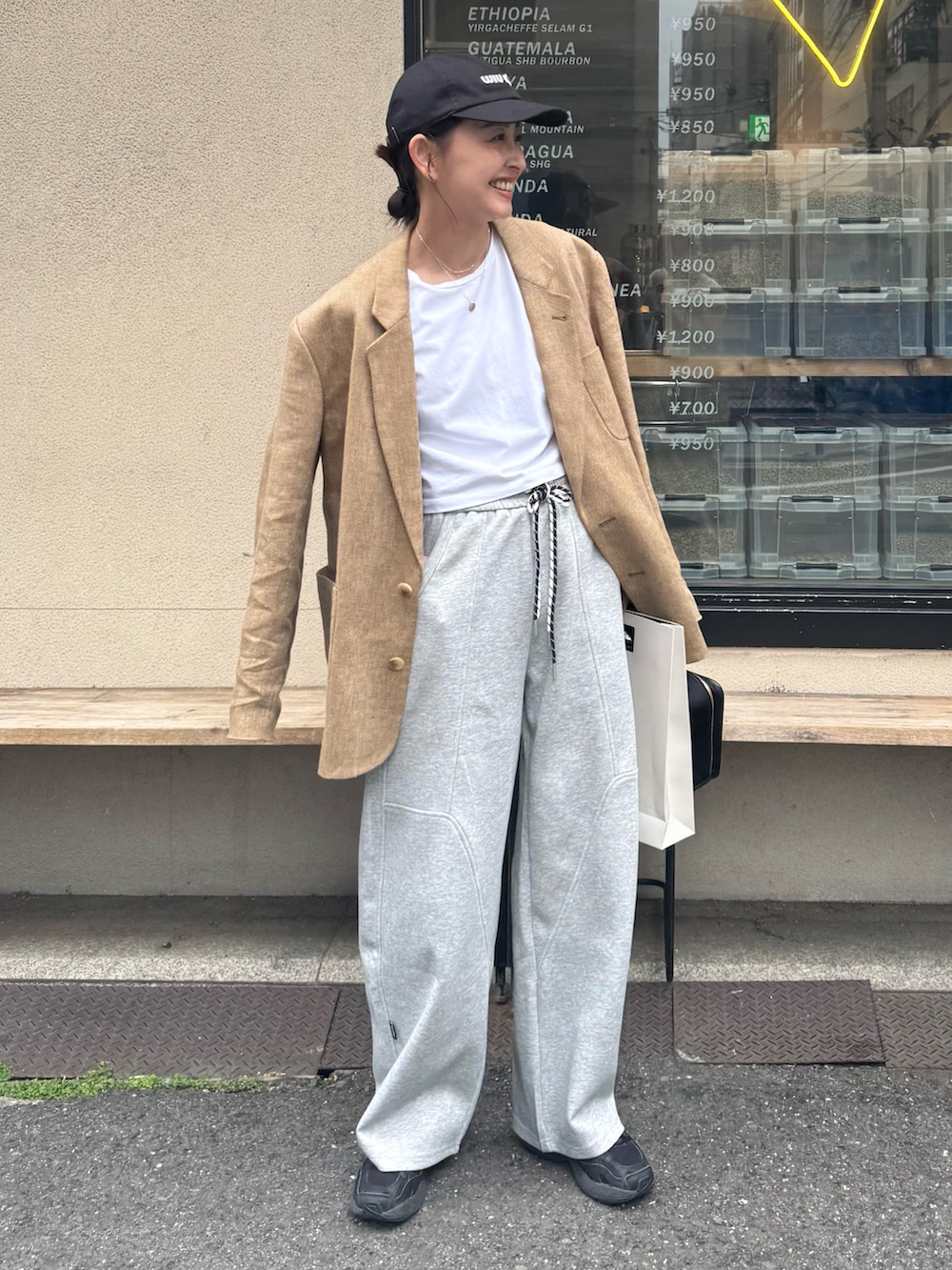 グレー系のスウェットパンツ、ブラック系のスニーカー、ベージュ系のテーラードジャケットを着用したレディースの春コーディネートの4枚目の写真
