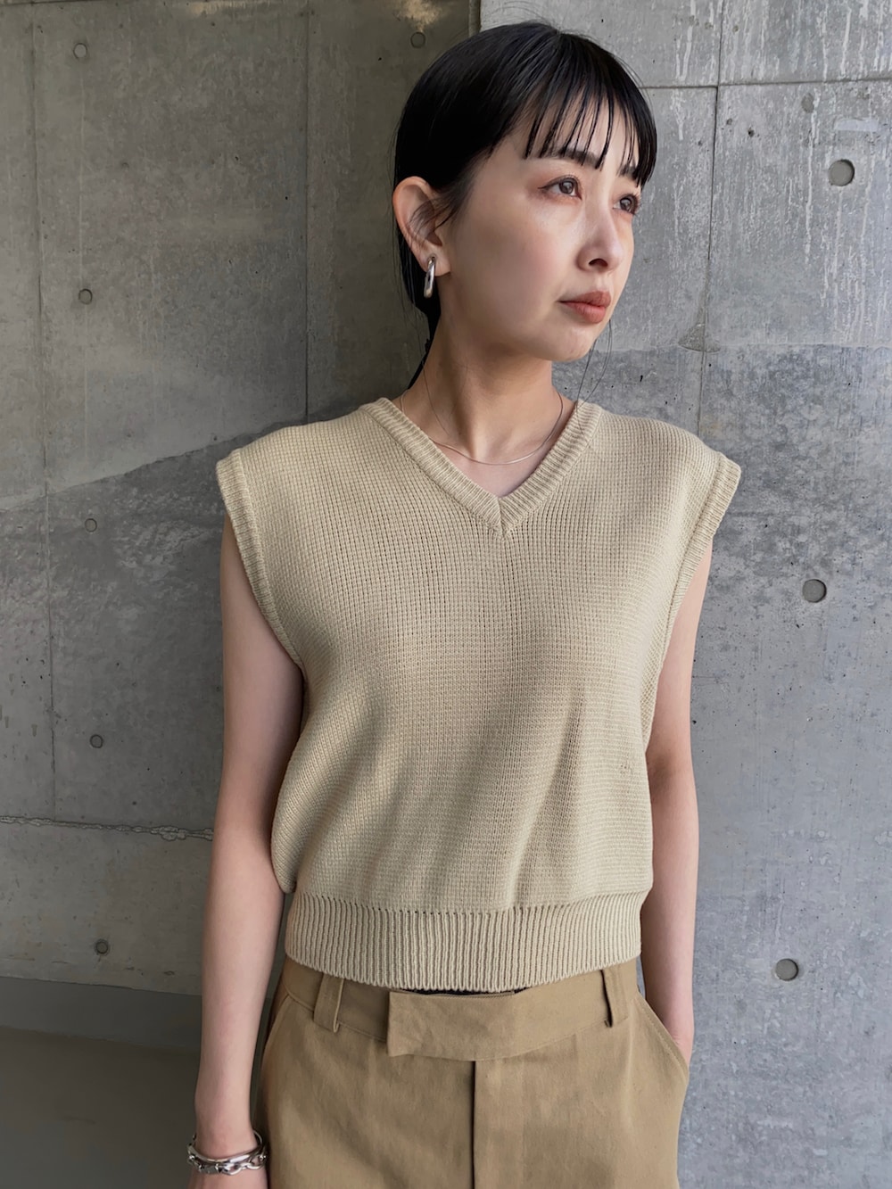 ベージュ系のスカート、ブラック系のローファー、ブラック系のハンドバッグを着用したレディースの夏コーディネートの2枚目の写真