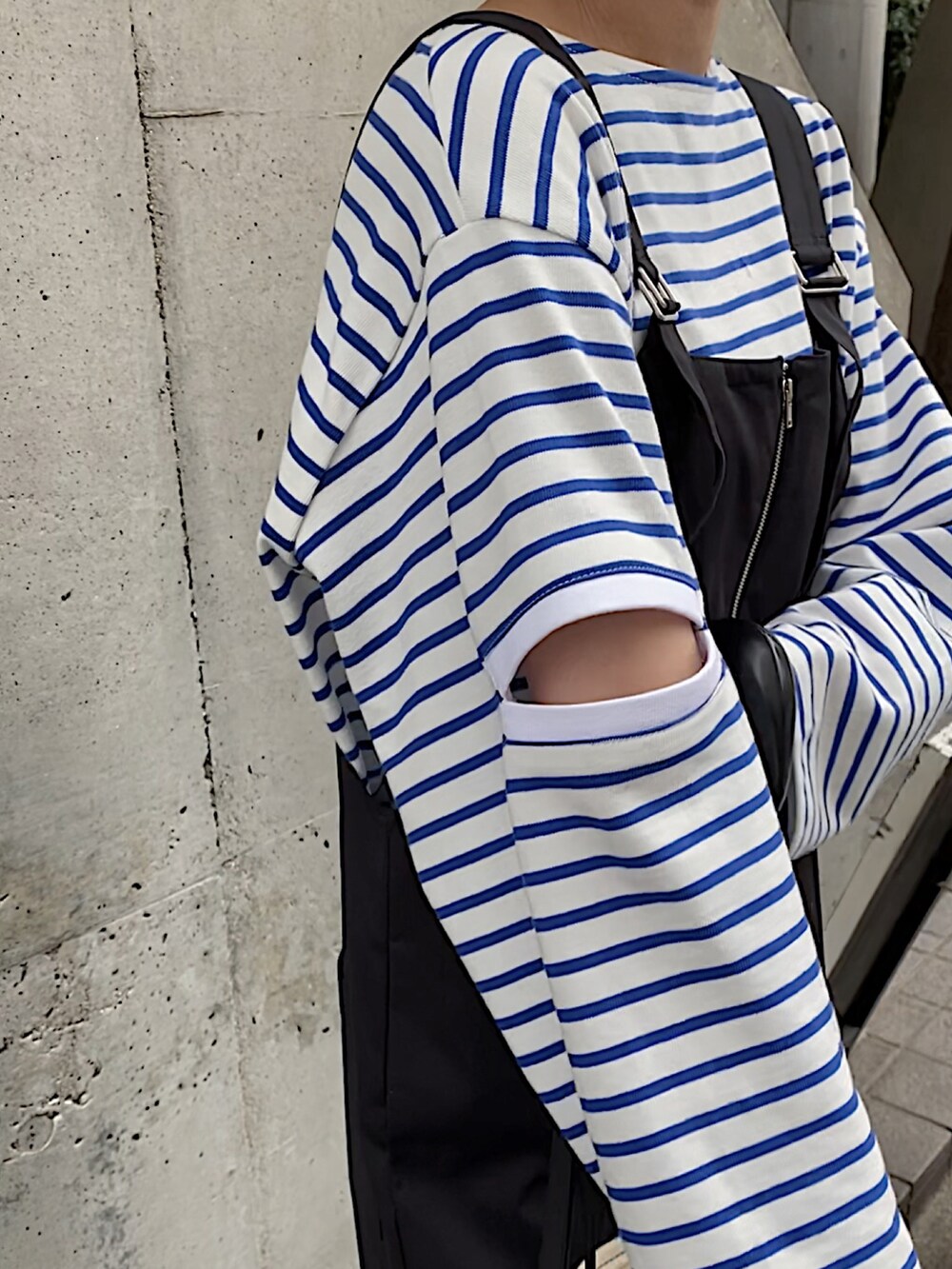 ブラック系のバレエシューズ、ブルー系のTシャツ/カットソー、ブラック系のサロペット/オーバーオールを着用したレディースの春コーディネートの3枚目の写真