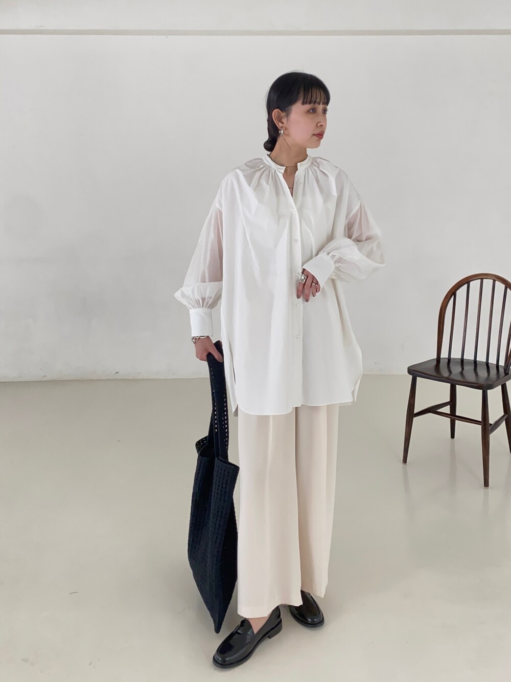 ブラック系のシャツ/ブラウス、ブラック系のトートバッグを着用したレディースの春コーディネートの2枚目の写真