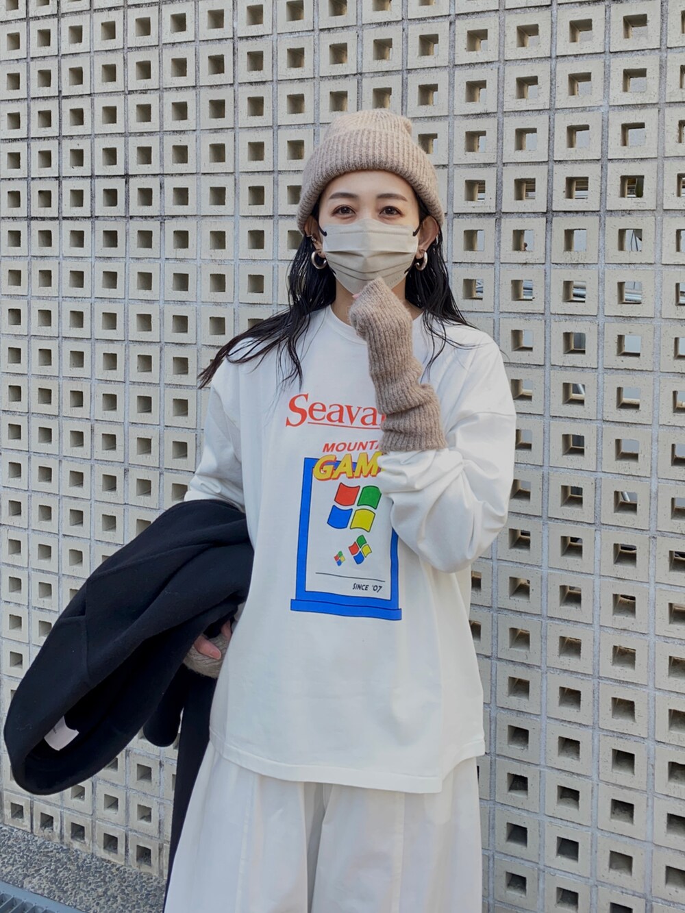 ホワイト系のTシャツ/カットソー、ホワイト系のチノパンツ、ブラック系のブーツを着用したレディースの冬コーディネートの3枚目の写真