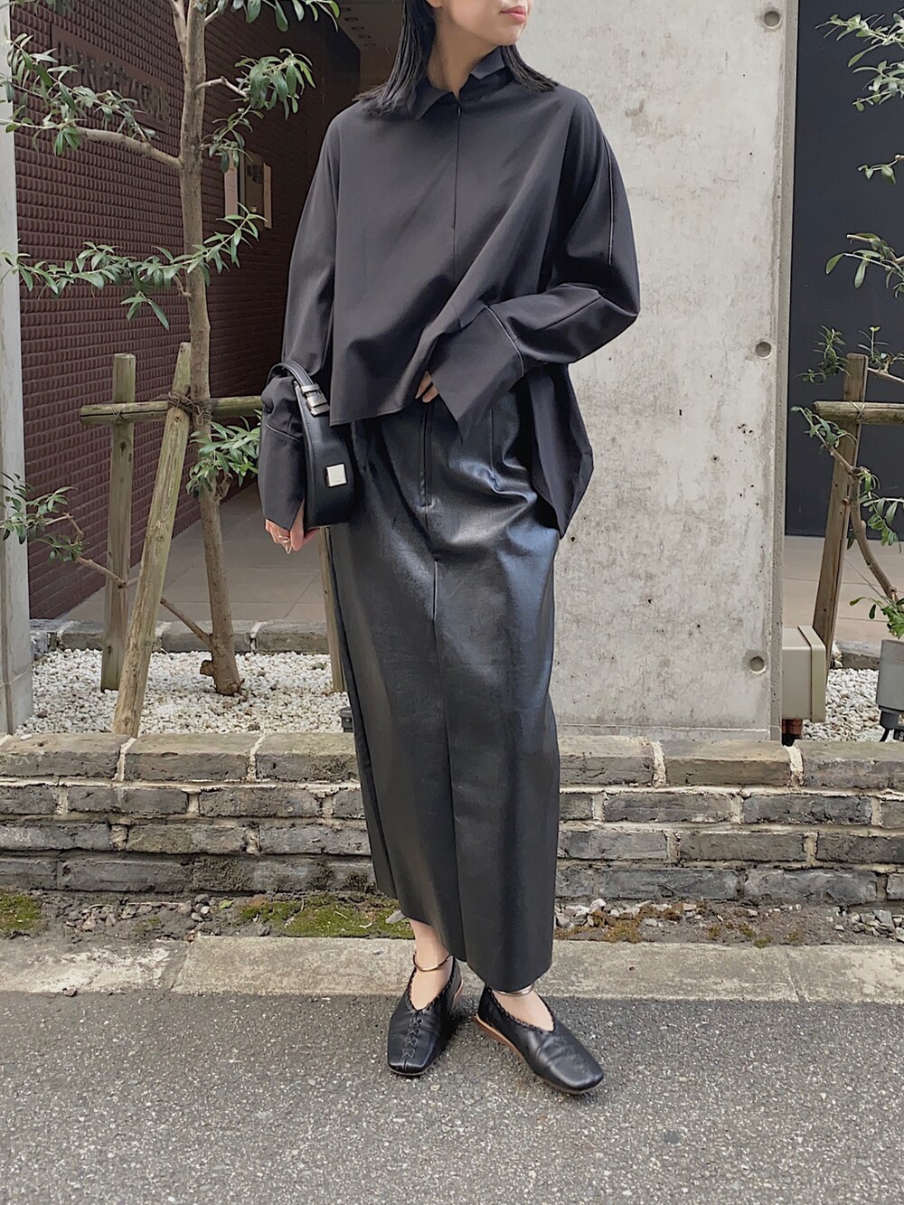 ブラック系のシャツ/ブラウス、ブラック系のハンドバッグを着用したレディースの冬コーディネートの2枚目の写真