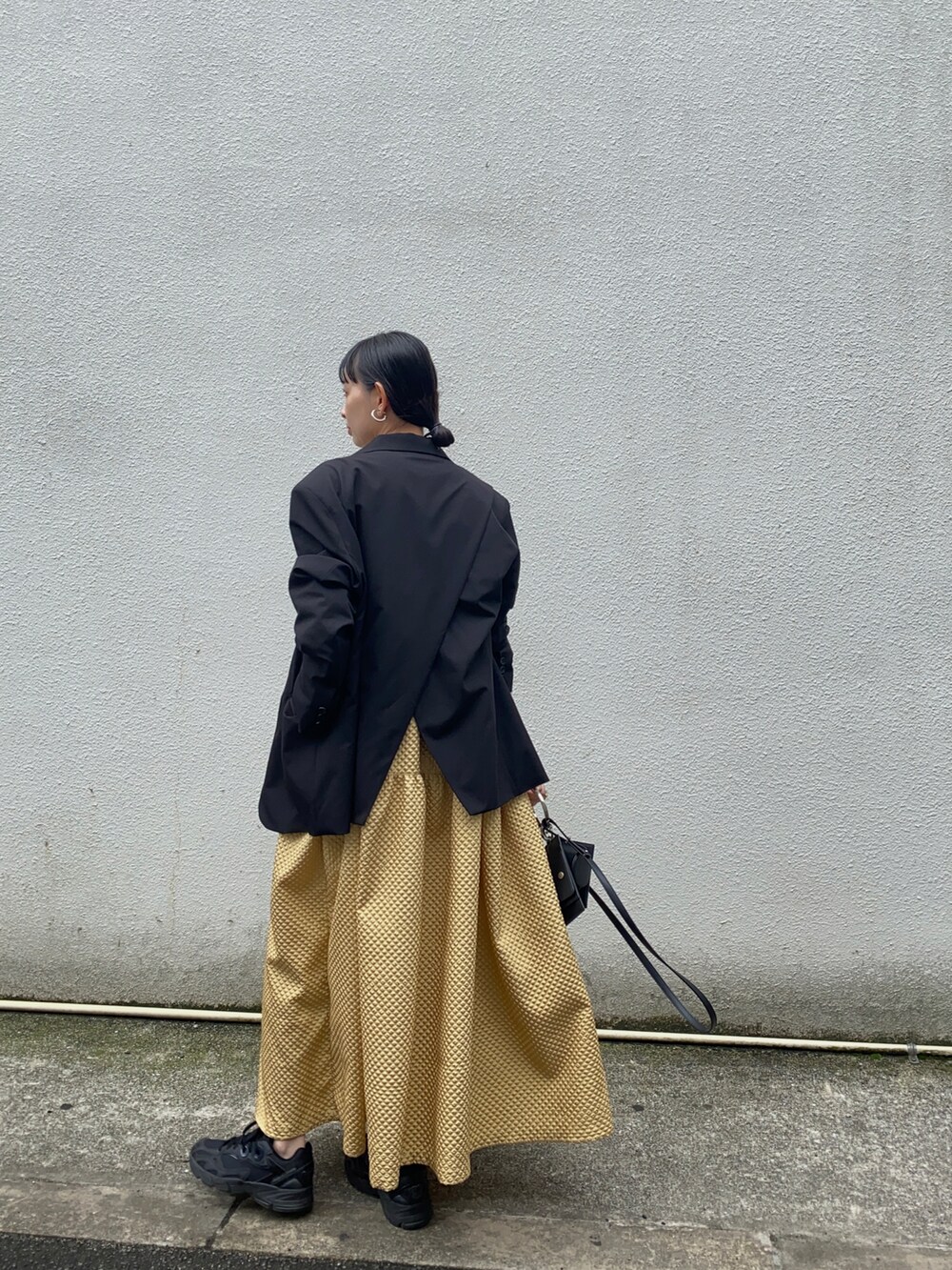 ブラック系のテーラードジャケット、ブラック系のショルダーバッグ、ブラック系のスニーカーを着用したレディースの春コーディネートの2枚目の写真