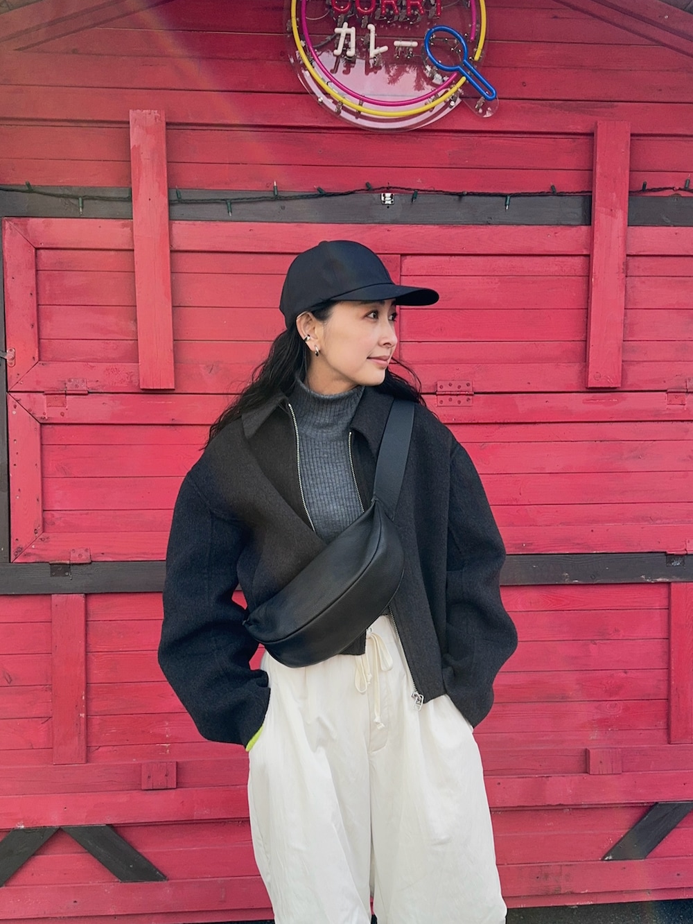 グレー系のブルゾン、ブラック系のショルダーバッグ、ホワイト系のその他パンツを着用したレディースの冬コーディネートの4枚目の写真