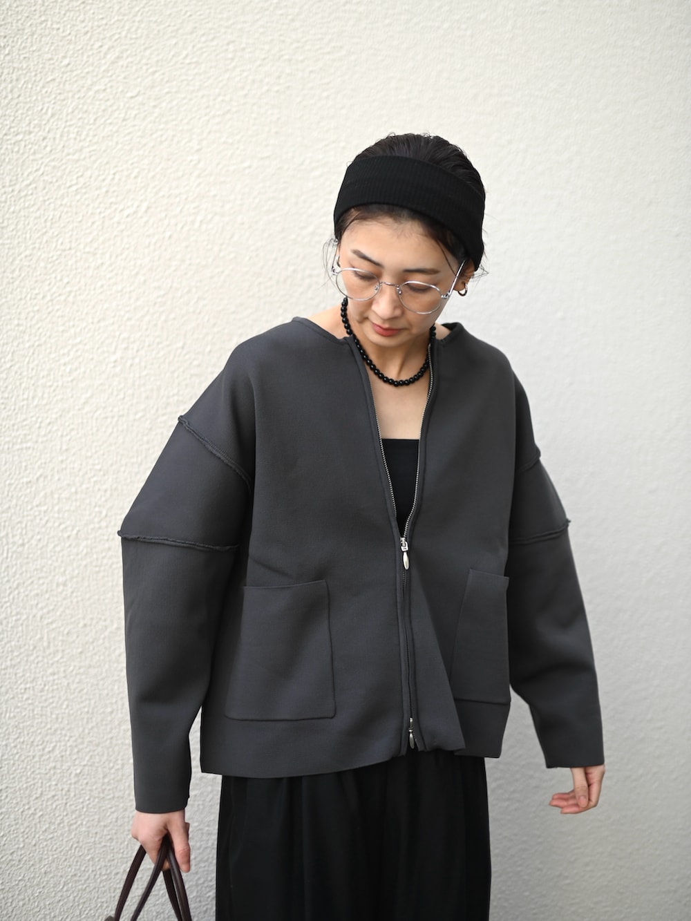 グレー系のカーディガン/ボレロ、ブラウン系のハンドバッグ、ブラック系のスラックスを着用したレディースの冬コーディネートの3枚目の写真