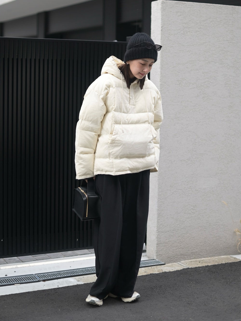 ブラック系のダウンジャケット/コート、シルバー系のスニーカー、ブラック系のサングラスを着用したレディースの冬コーディネートの4枚目の写真