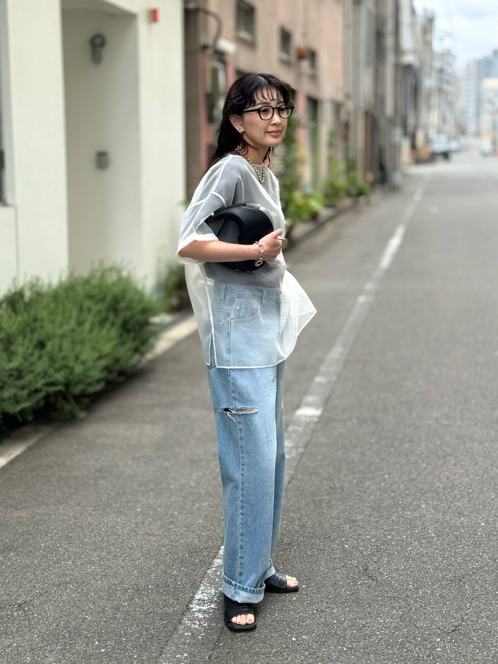 ホワイト系のシャツ/ブラウス、ブルー系のデニムパンツ、ブラック系のハンドバッグを着用したレディースの春コーディネートの4枚目の写真