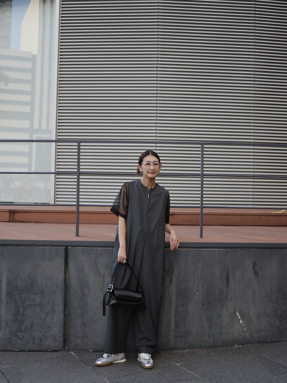 ブラック系のショルダーバッグ、シルバー系のスニーカー、グレー系のつなぎ/オールインワンを着用したレディースの秋コーディネートの4枚目の写真