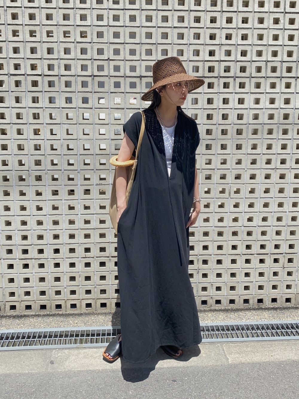 ブラック系のワンピース、ブラウン系のハット、シルバー系のネックレスを着用したレディースの夏コーディネートの2枚目の写真