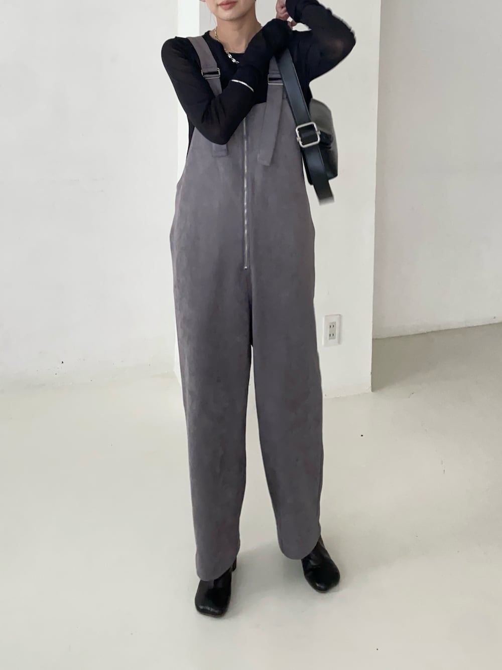 ブラック系のTシャツ/カットソー、グレー系のサロペット/オーバーオール、ブラック系のショルダーバッグを着用したレディースの秋コーディネートの3枚目の写真