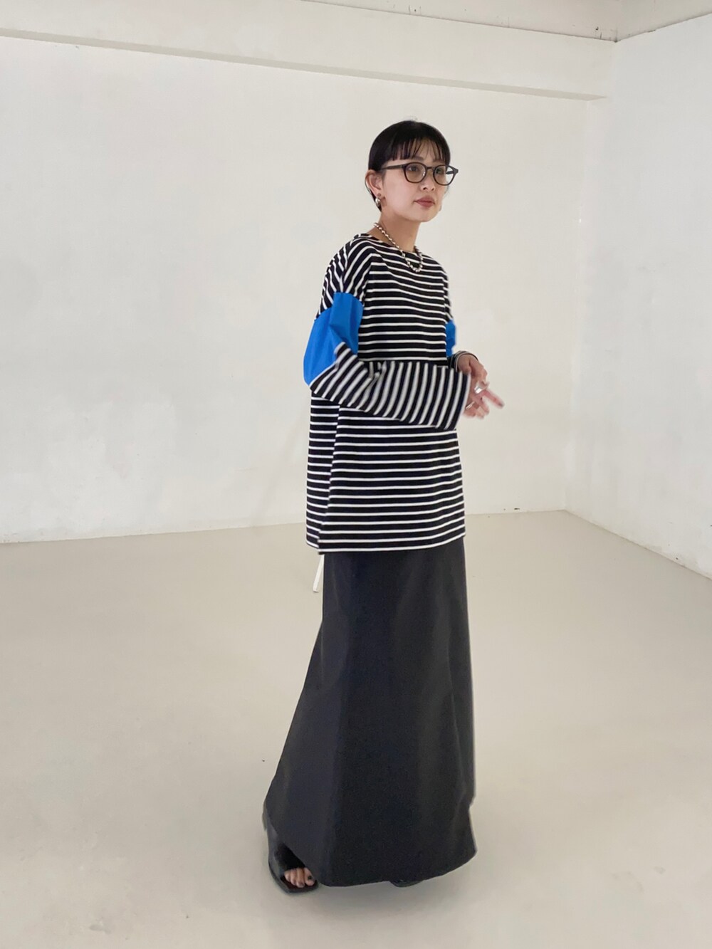 ブルー系のTシャツ/カットソー、ブラック系のスカートを着用したレディースの春コーディネートの3枚目の写真