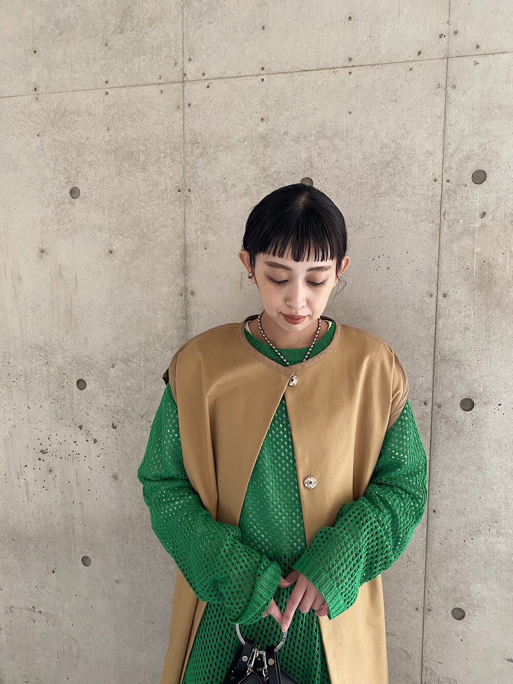 ベージュ系のその他アウター、グリーン系のニット/セーター、ブラック系のその他パンツを着用したレディースの春コーディネートの4枚目の写真