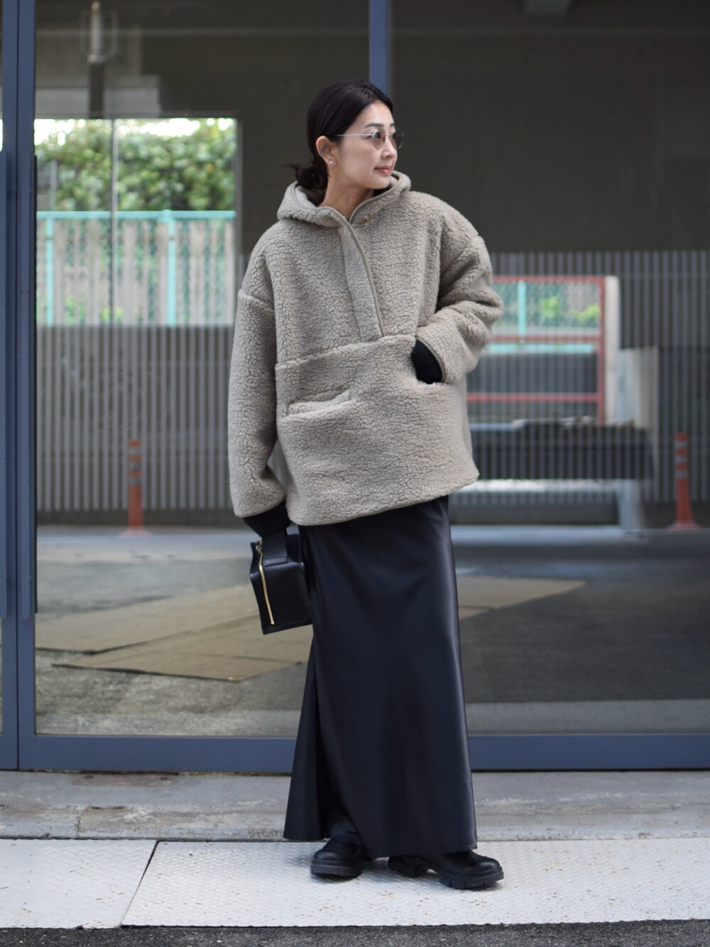 グリーン系のブルゾン、ブラック系のスカート、ブラック系のブーツを着用したレディースの冬コーディネートの2枚目の写真