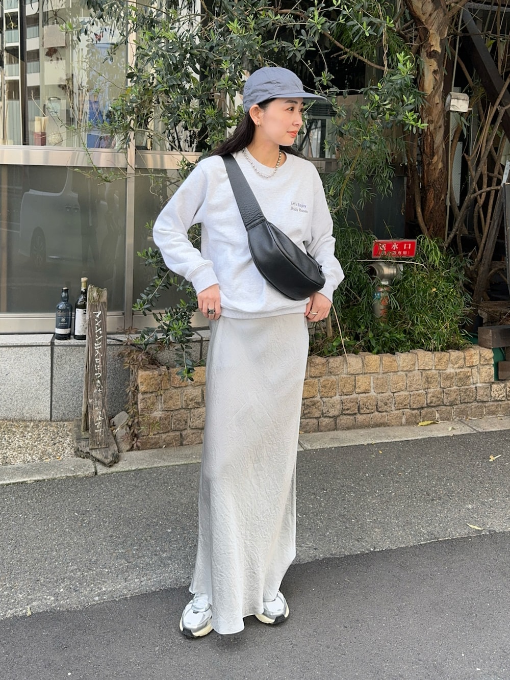 グレー系のスウェット、シルバー系のスカート、ホワイト系のスニーカーを着用したレディースの春コーディネートの4枚目の写真