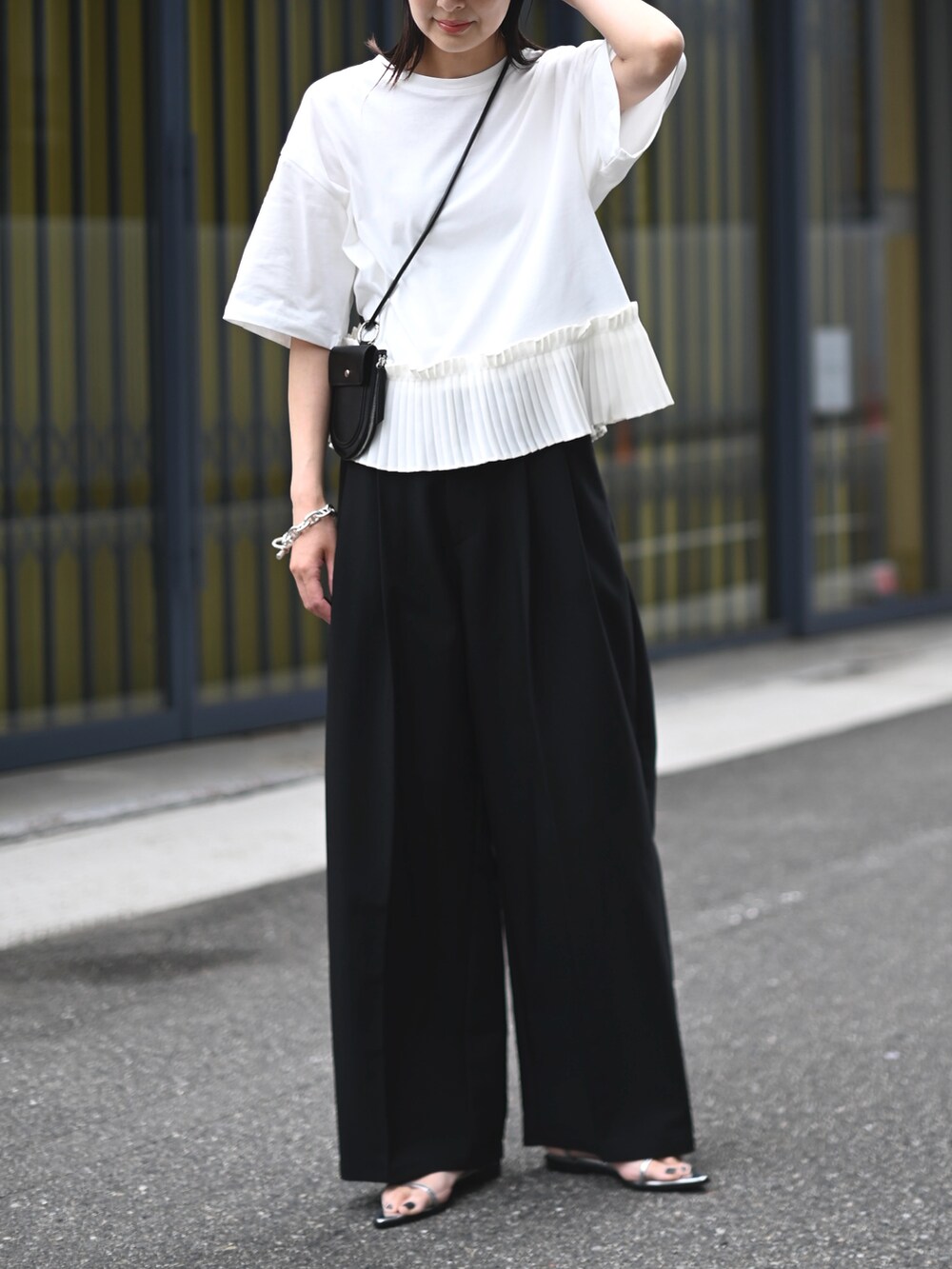 ホワイト系のTシャツ/カットソー、シルバー系のサンダル、ブラック系の財布/小物を着用したレディースの春コーディネートの4枚目の写真