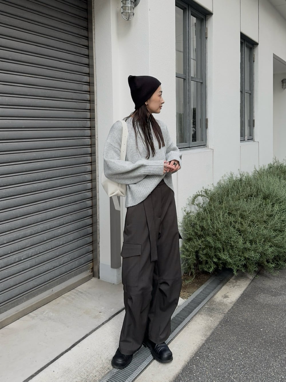 グレー系のニット/セーター、ホワイト系のショルダーバッグ、グレー系のパンツを着用したレディースの秋コーディネートの4枚目の写真