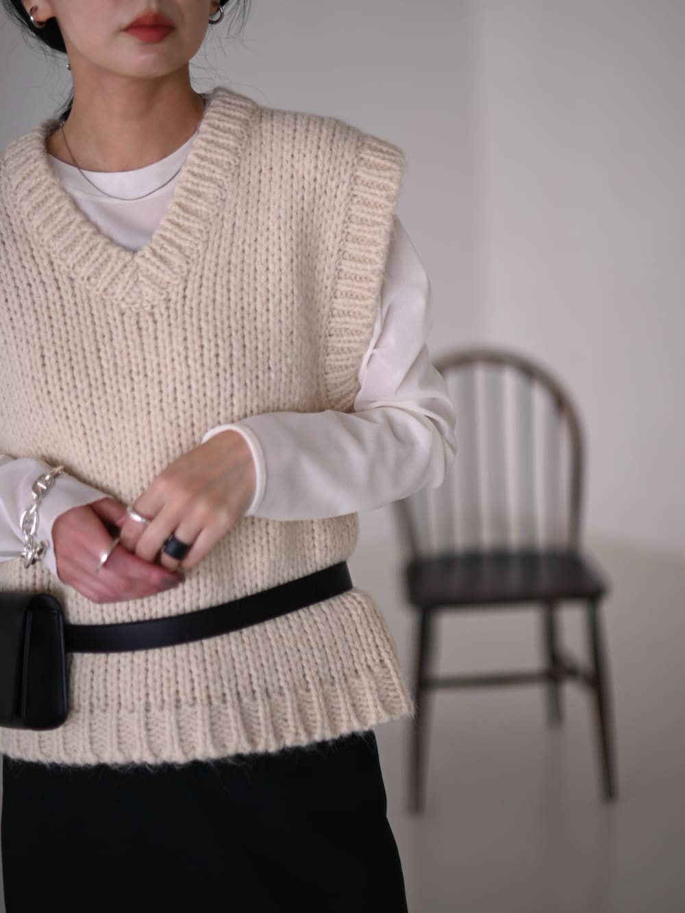 ホワイト系のベスト、ホワイト系のTシャツ/カットソー、ブラック系のスラックスを着用したレディースの冬コーディネートの3枚目の写真