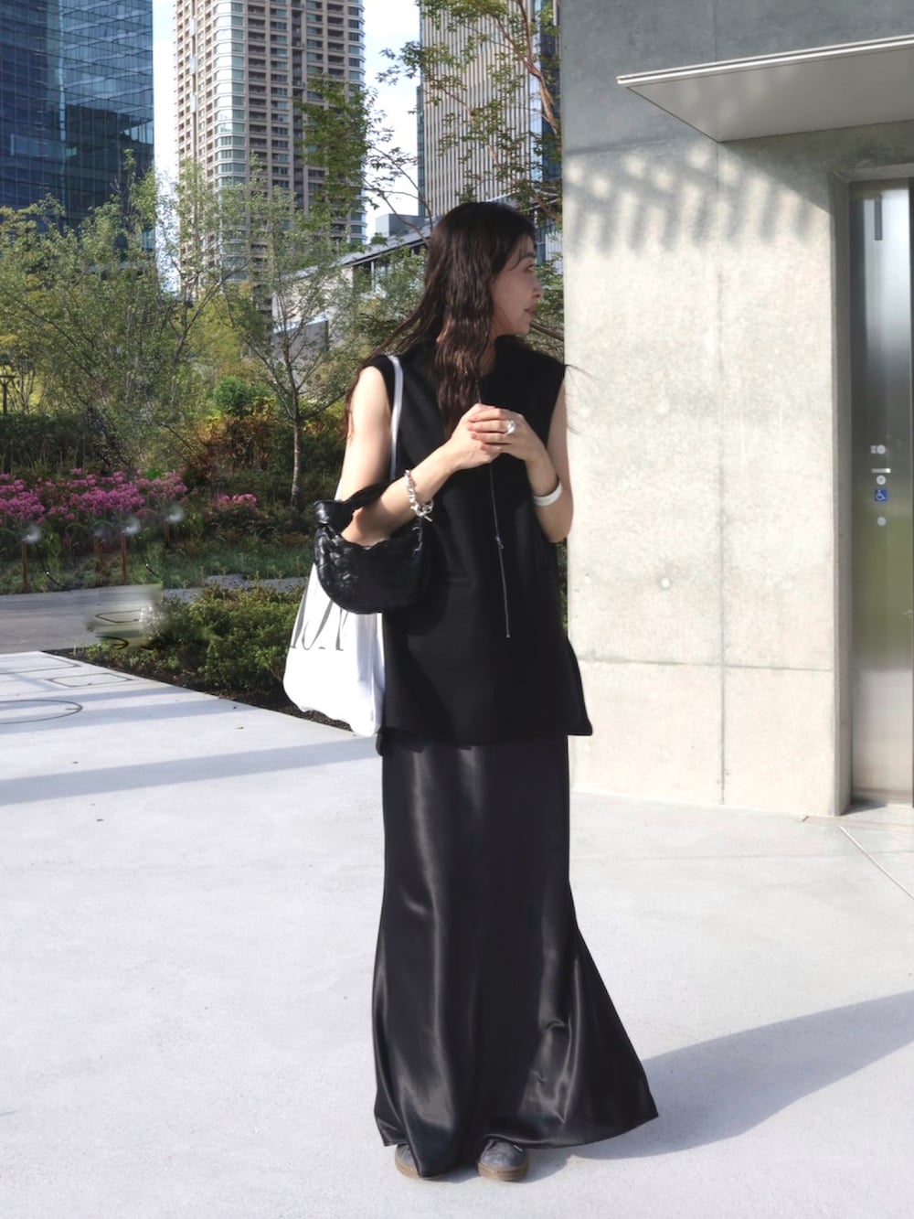 ブラック系のベスト、ホワイト系のトートバッグ、グレー系のスニーカーを着用したレディースの秋コーディネートの2枚目の写真