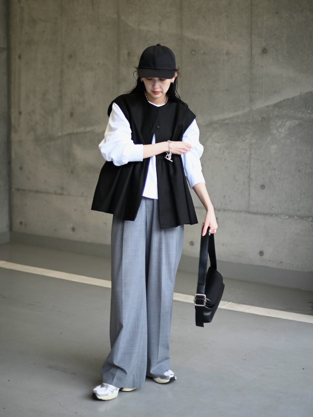 ブラック系のその他アウター、グレー系のスラックス、ホワイト系のスニーカーを着用したレディースの冬コーディネートの2枚目の写真