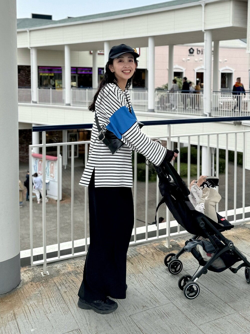 ブルー系のTシャツ/カットソー、ブラック系のスカート、ブラック系のスニーカーを着用したレディースの春コーディネートの3枚目の写真