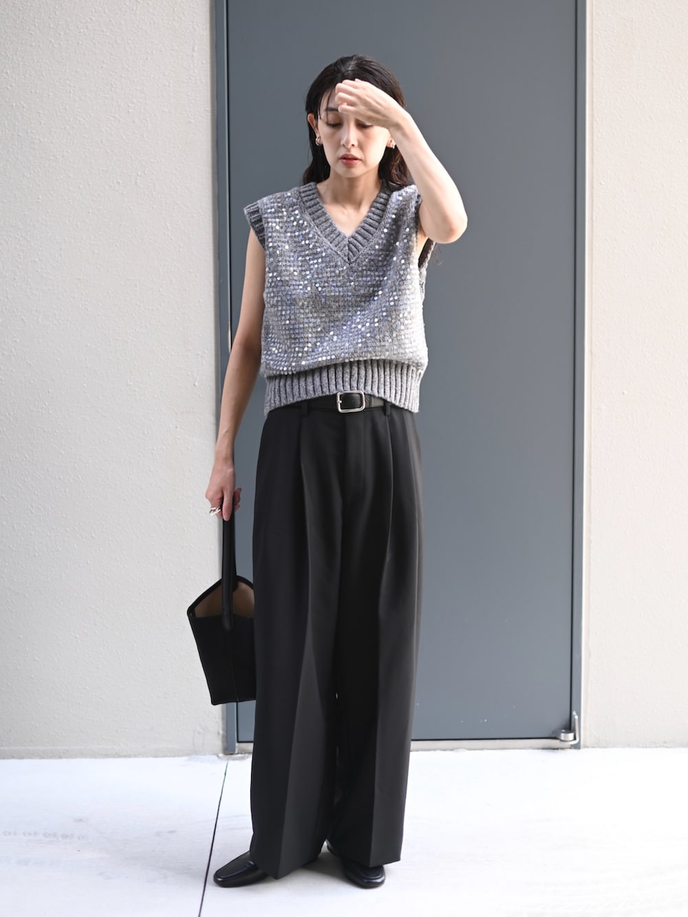 グレー系のニット/セーター、ブラック系のスラックス、ブラック系のベルトを着用したレディースの秋コーディネートの2枚目の写真