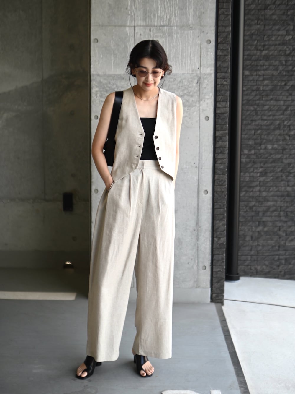 ベージュ系のベスト、ベージュ系のその他パンツ、ブラック系のショルダーバッグを着用したレディースの夏コーディネートの3枚目の写真