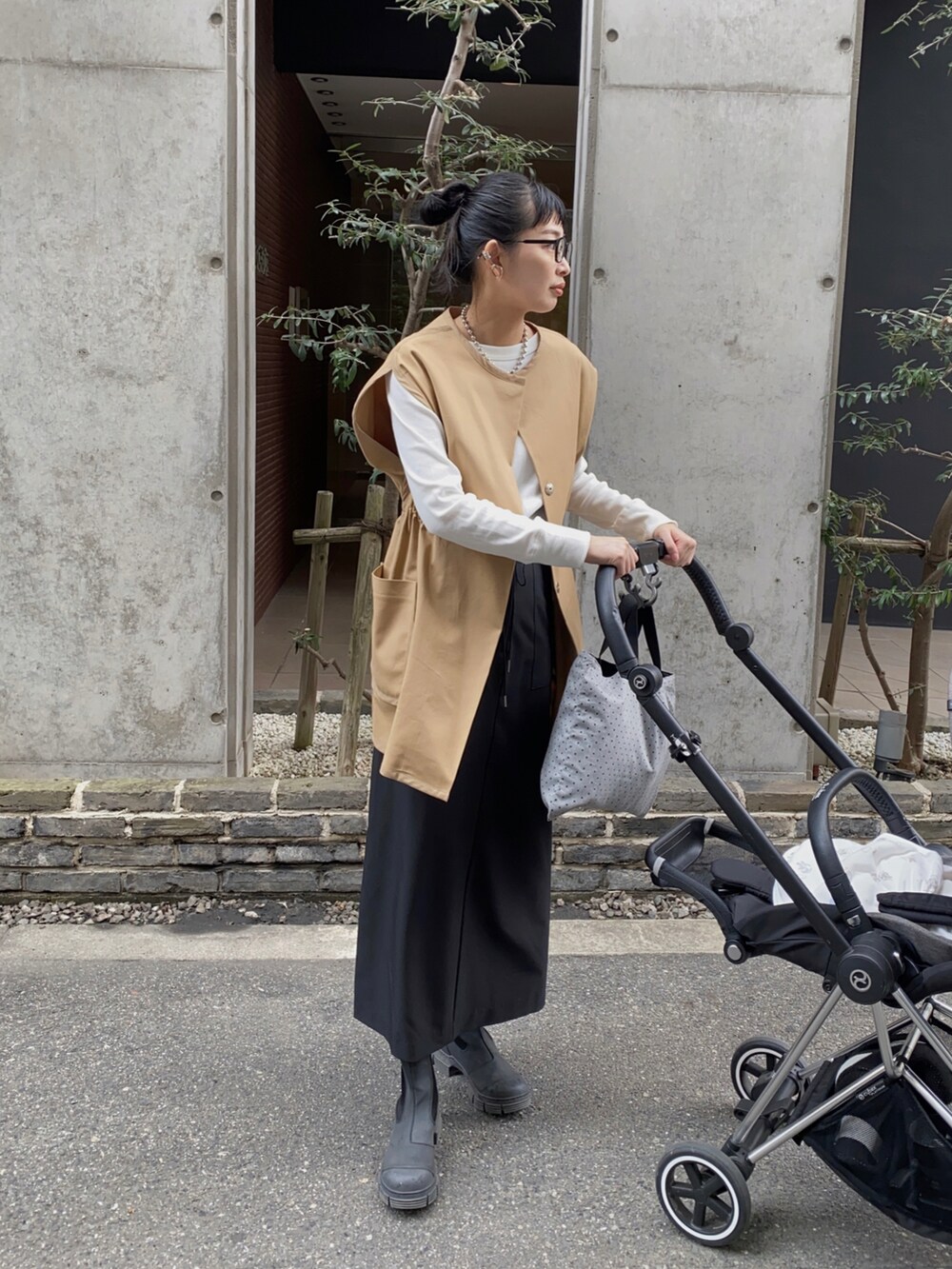 ベージュ系のベスト、ホワイト系のTシャツ/カットソー、ブラック系のスカートを着用したレディースの秋コーディネートの2枚目の写真
