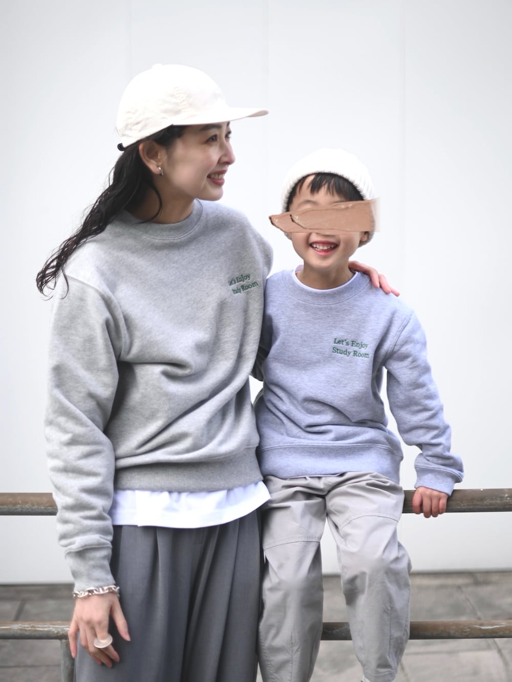 グレー系のスウェット、グレー系のスラックス、ホワイト系のスニーカーを着用したレディースの春コーディネートの2枚目の写真