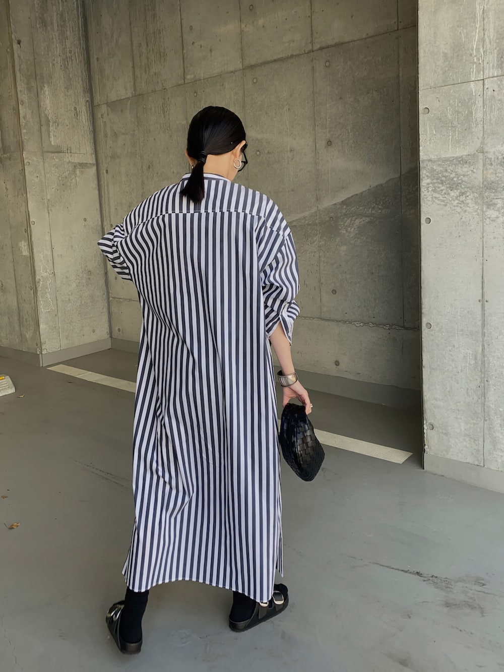 ホワイト系のシャツワンピース、ブラック系のサンダル、シルバー系のリングを着用したレディースの春コーディネートの3枚目の写真