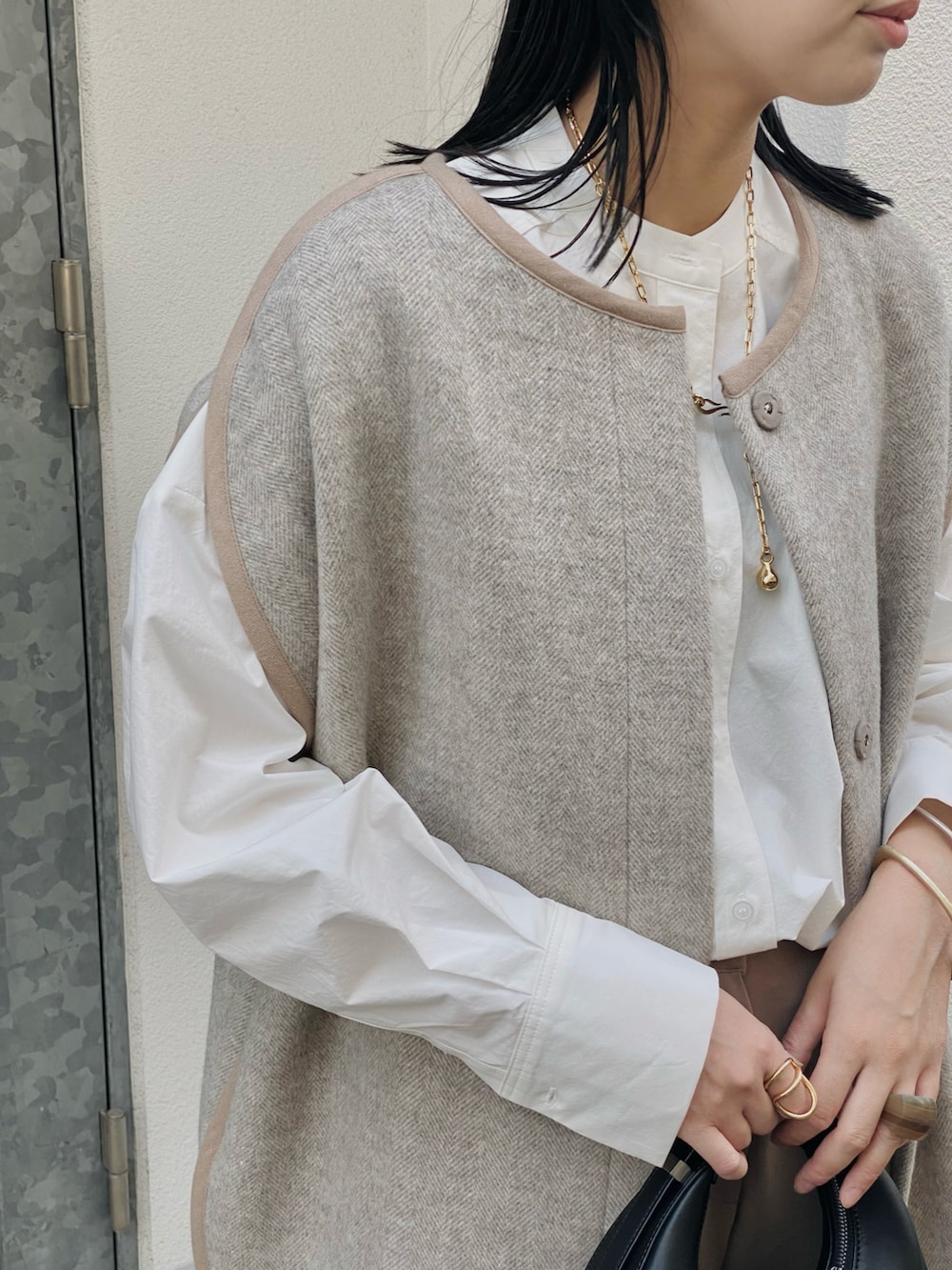 ベージュ系のその他アウター、ホワイト系のシャツ/ブラウス、ブラック系のハンドバッグを着用したレディースの秋コーディネートの2枚目の写真