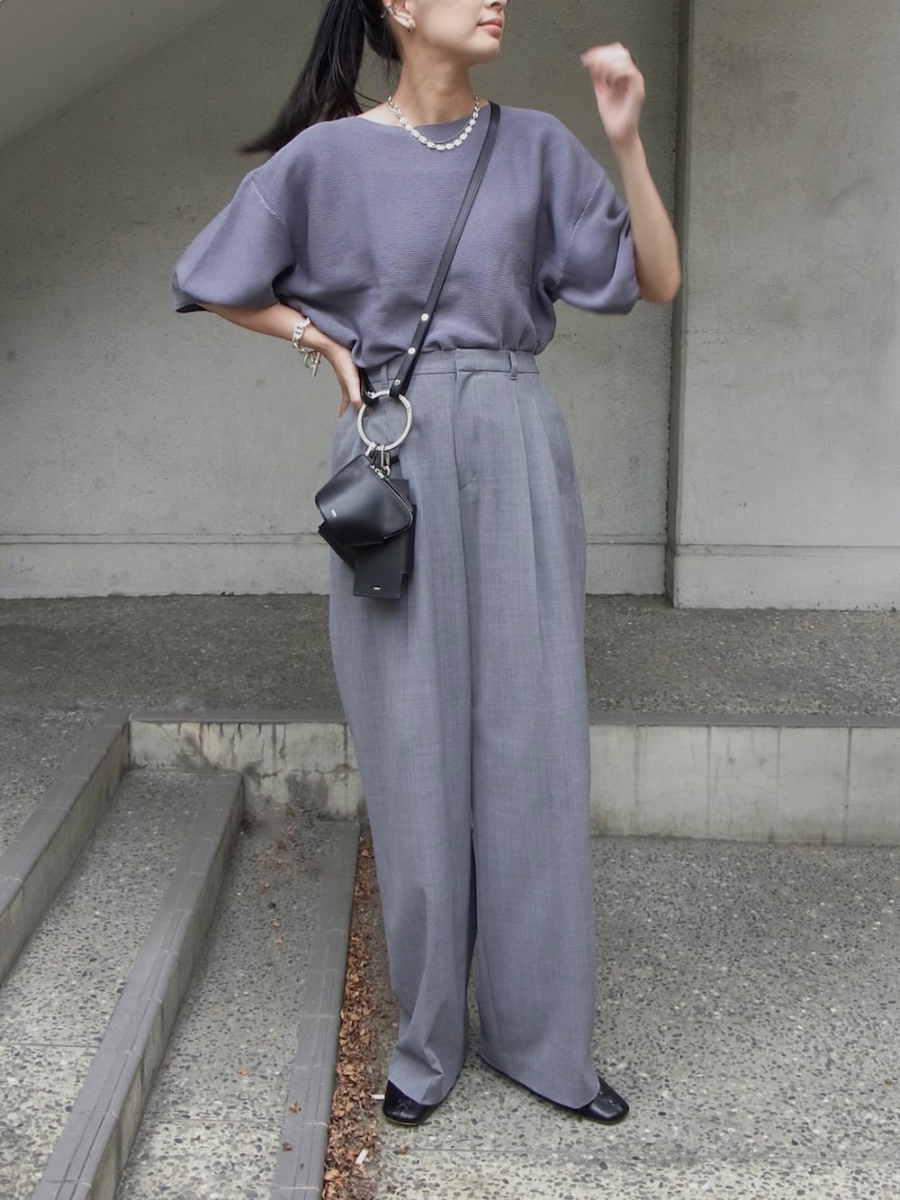 ブルー系のニット/セーター、グレー系のスラックス、ブラック系のショルダーバッグを着用したレディースの秋コーディネートの3枚目の写真