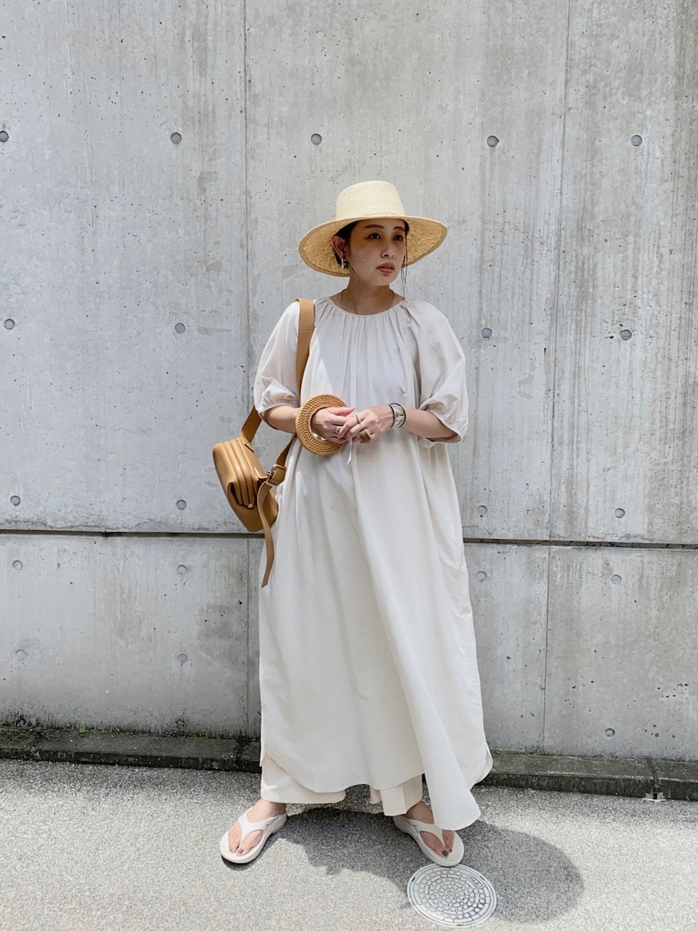 ホワイト系のワンピース、ブラウン系のショルダーバッグ、ホワイト系のサンダルを着用したレディースの夏コーディネートの2枚目の写真