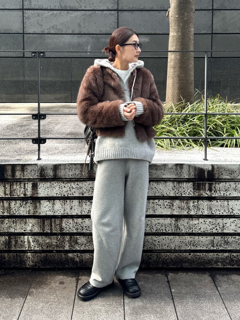 ブラウン系のその他アウター、グレー系のニット/セーター、ブラック系のキーホルダーを着用したレディースの冬コーディネートの2枚目の写真