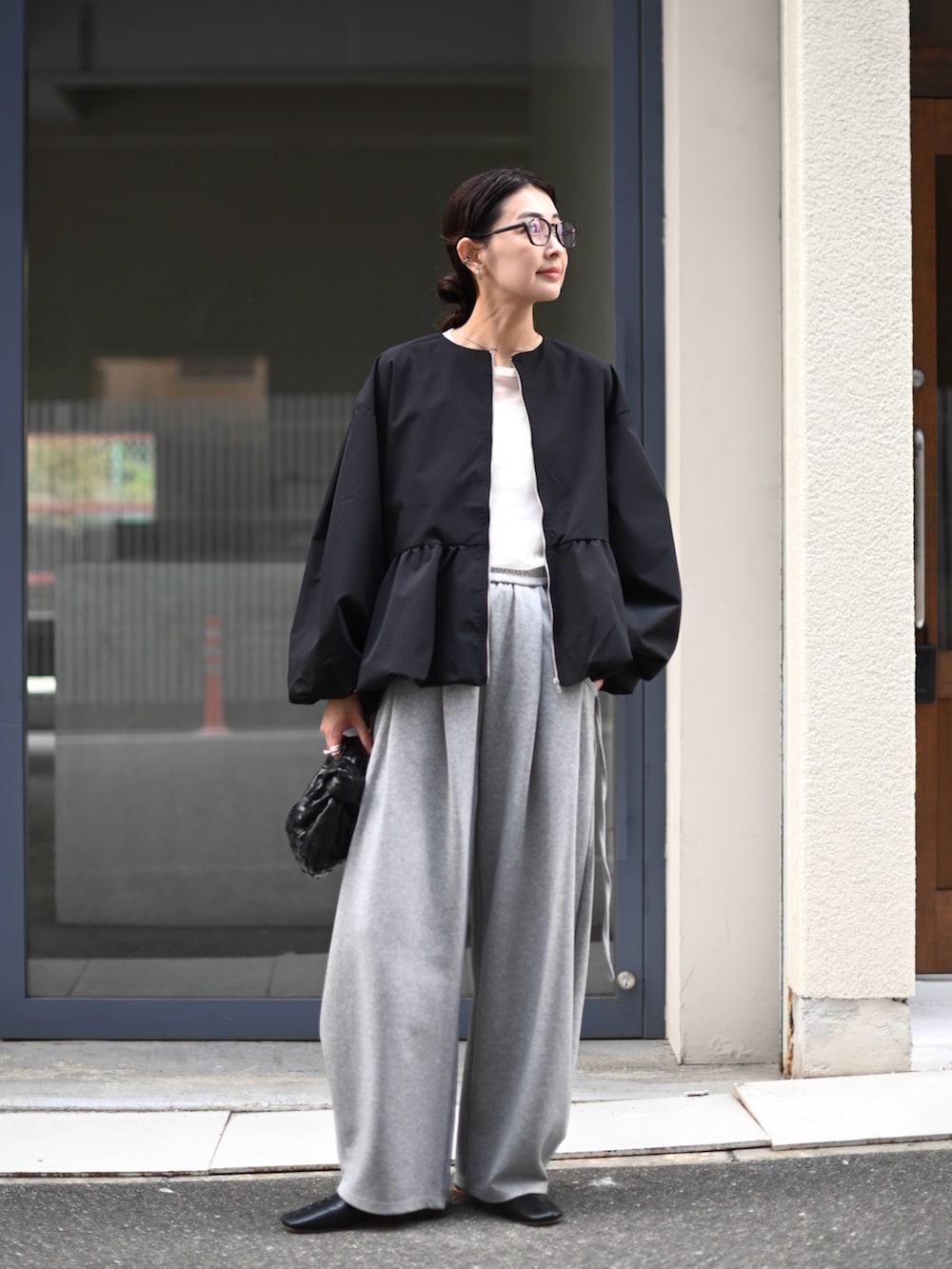 ブラック系のブルゾン、グレー系のスウェットパンツを着用したレディースの秋コーディネートの5枚目の写真