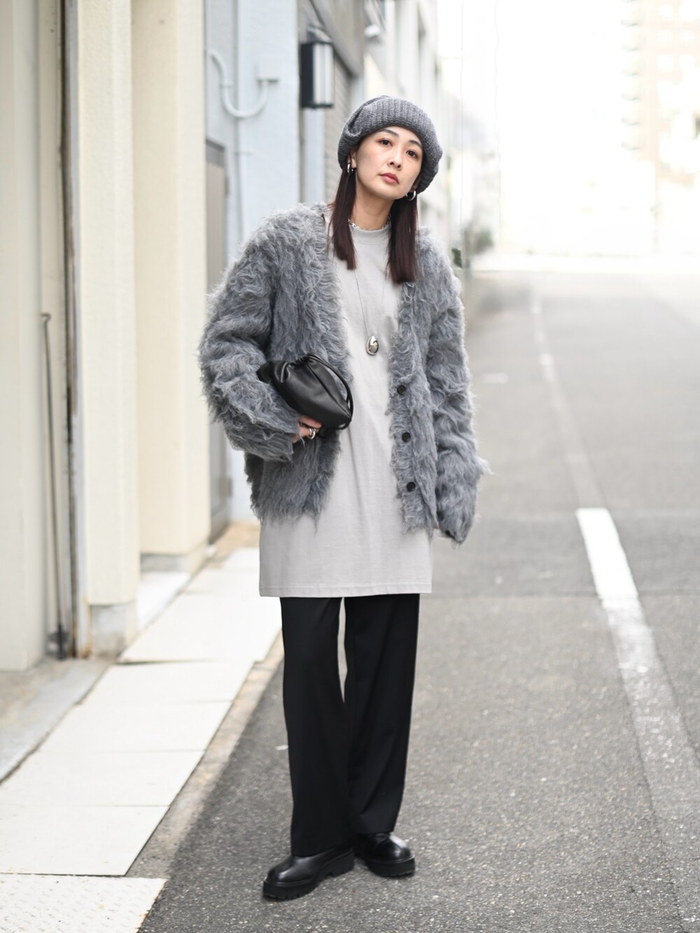 グレー系のカーディガン/ボレロ、ブラック系のスラックス、グレー系のニットキャップ/ビーニーを着用したレディースの冬コーディネートの2枚目の写真