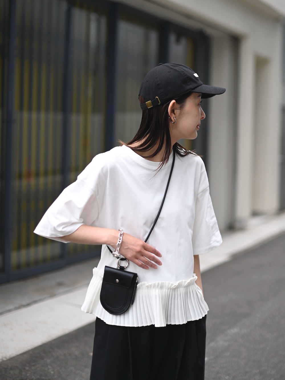 ホワイト系のTシャツ/カットソー、シルバー系のサンダル、ブラック系の財布/小物を着用したレディースの春コーディネートの3枚目の写真