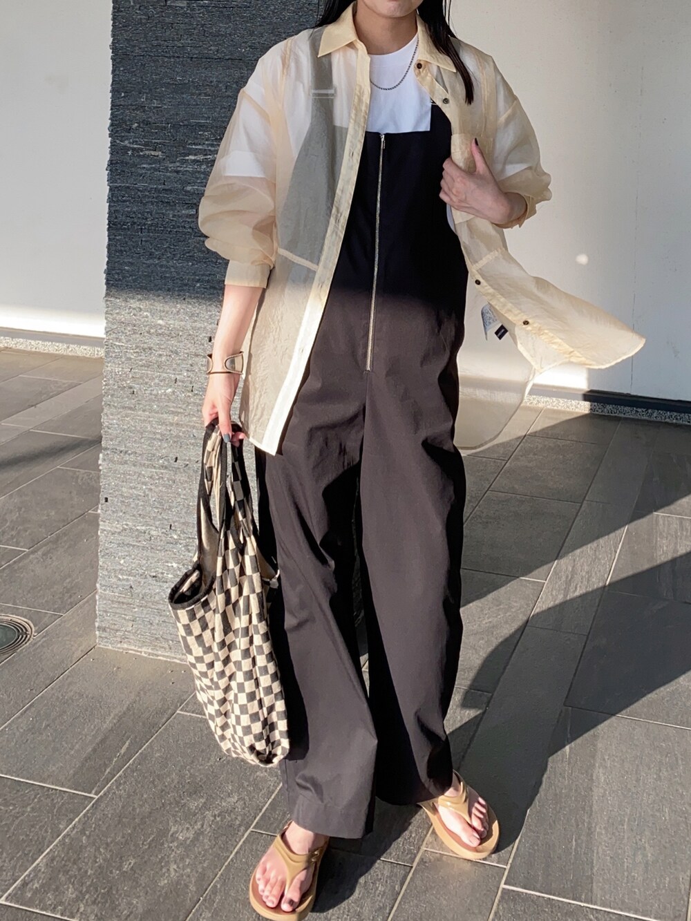 ブラック系のサロペット/オーバーオール、ベージュ系のサンダル、ホワイト系のTシャツ/カットソーを着用したレディースの夏コーディネートの2枚目の写真