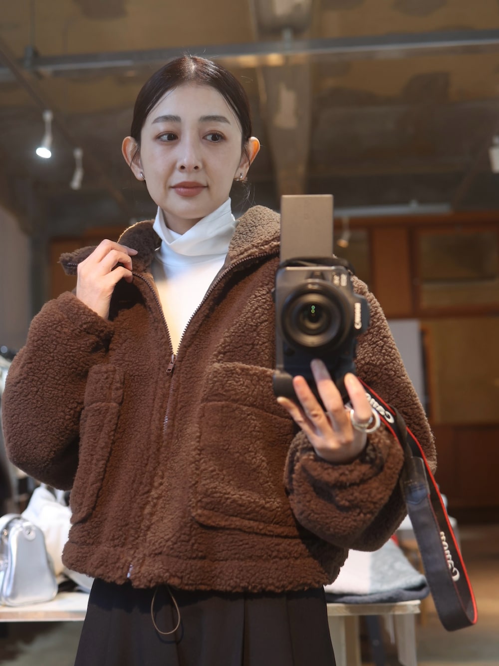 ブラウン系のその他アウター、ブラック系のスラックス、ブラック系のブーツを着用したレディースの冬コーディネートの4枚目の写真