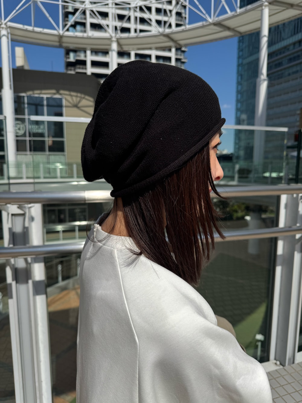 ブラック系のスウェットパンツ、ベージュ系のステンカラーコート、ブラック系のニットキャップ/ビーニーを着用したレディースの春コーディネートの4枚目の写真