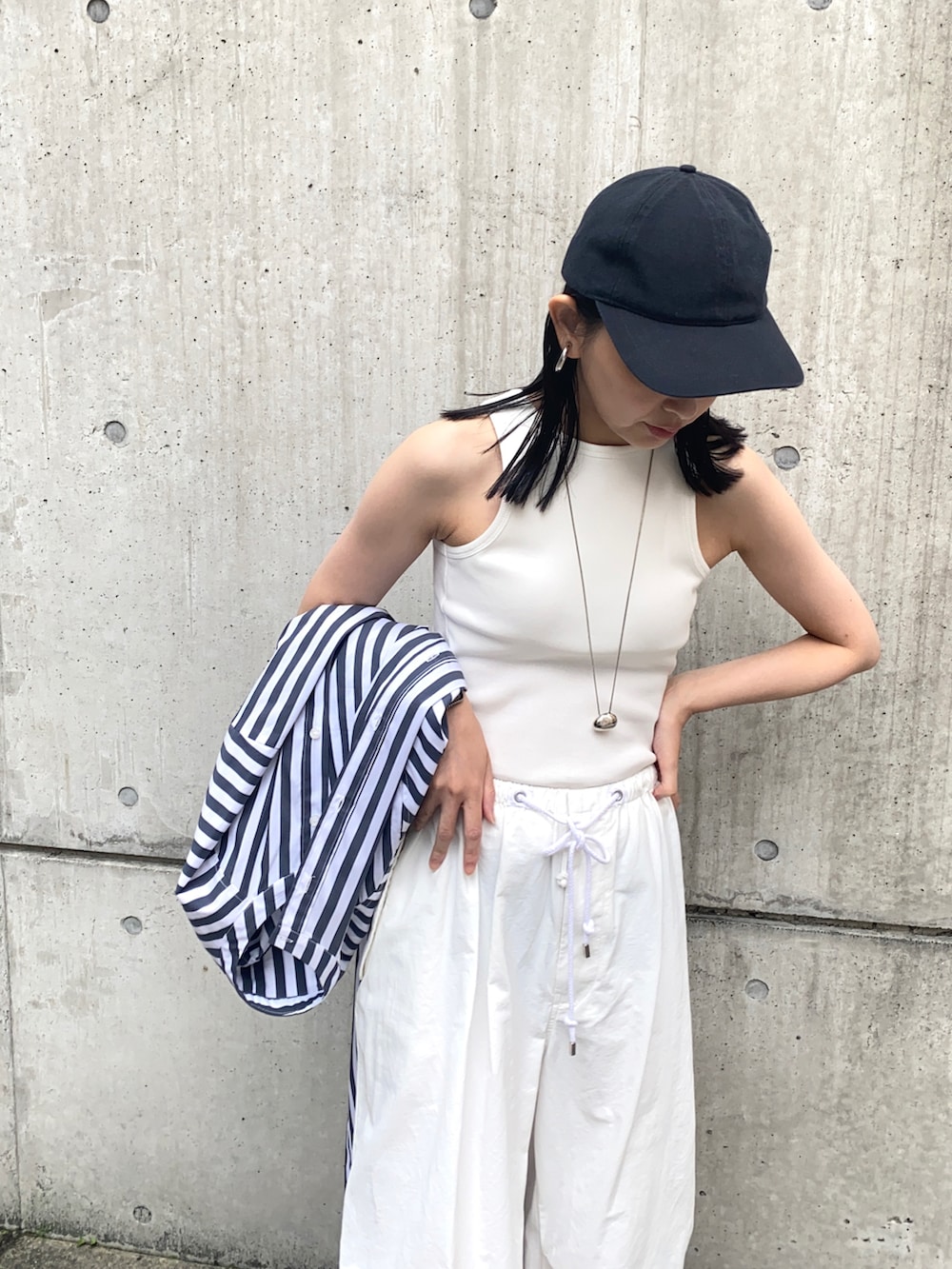 ホワイト系のタンクトップ、ホワイト系のカーゴパンツ、ホワイト系のサンダルを着用したレディースの夏コーディネートの2枚目の写真